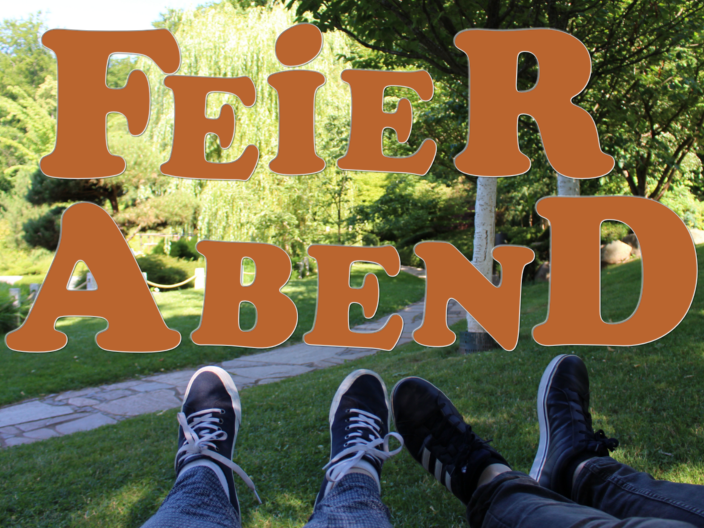Schrift Feierabend vor einem Park mit Füßen zweier Menschen
