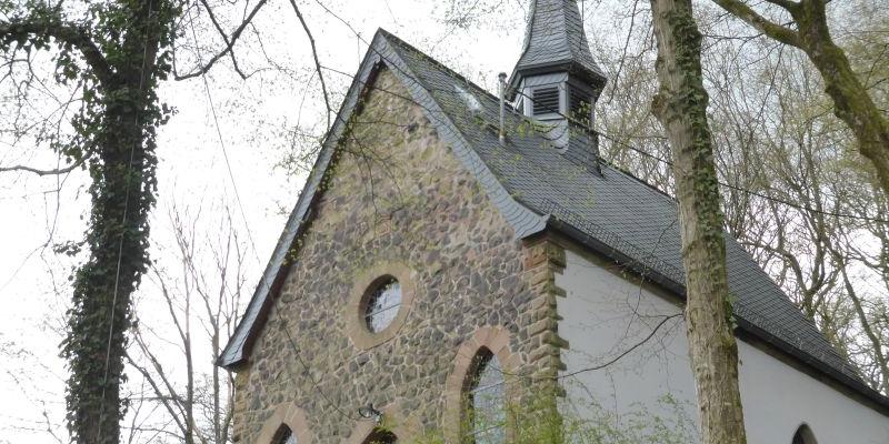 Eine kleine Kapelle auf einer Anhöhe zwischen kahlen Bäumen