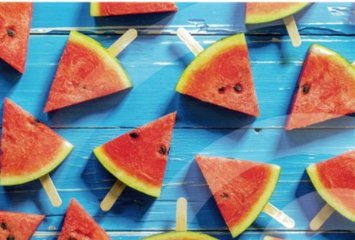 dreieckige Melonenstücke auf Stielen auf einem azurblauen Hintergrund