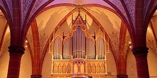 Eine Orgel mit bunter Hintergrundbeleuchtung mit einem Kirchengewölbe (c) Pastoraler Raum Lebach Eine Orgel mit bunter Hintergrundbeleuchtung mit einem Kirchengewölbe