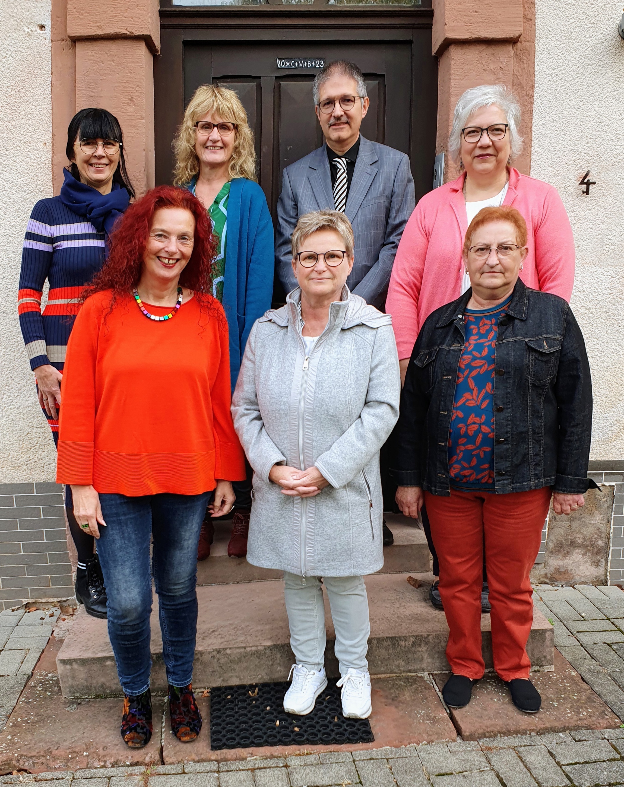 Sechs Frauen und ein Mann stehen auf einer Treppe